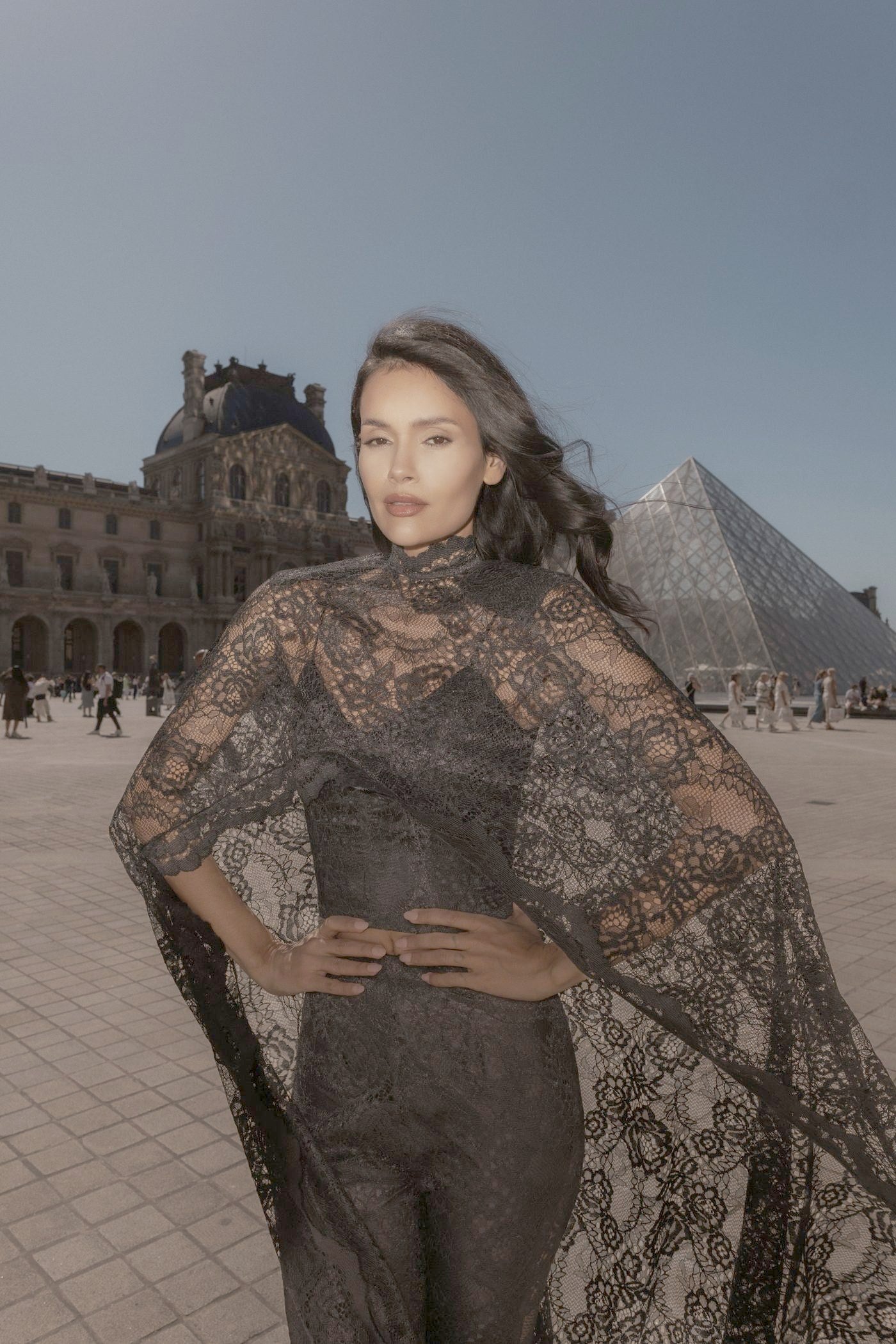 Model in a long black Chantilly lace cape in the Louvre courtyard, Paris