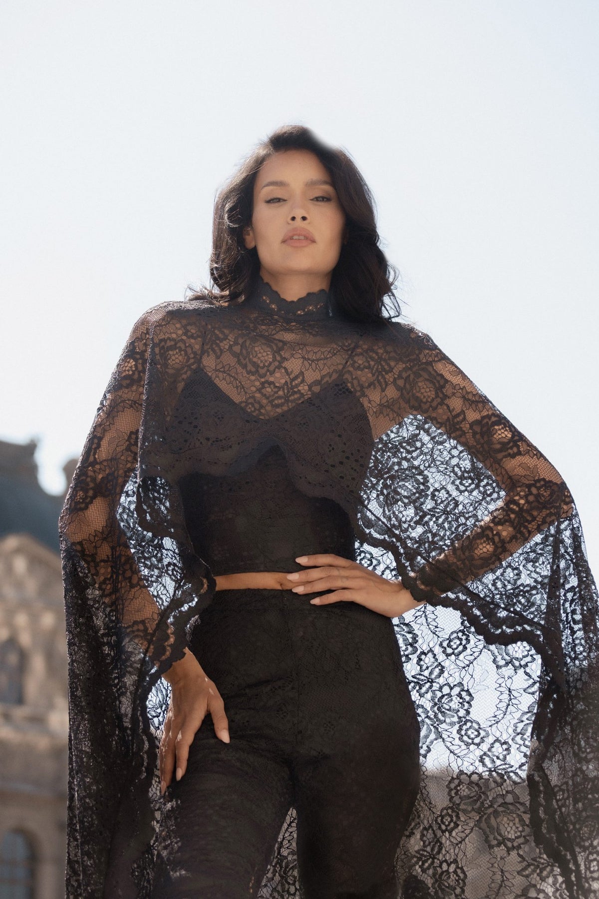 Black Chantilly lace Femme Cape and corset, half-length view showing the sheer lace over the fitted corset.