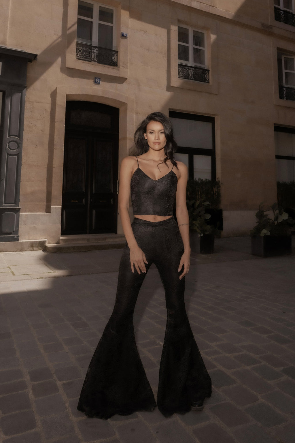 Black wide-leg Femme Pants, full-length front view, Paris.