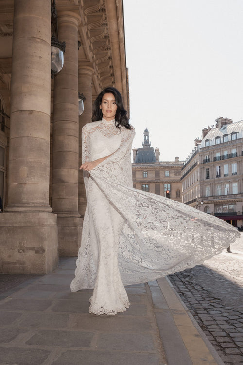 Model swirling in the white floor-length lace cape, the lace flaring out in motion, Paris.
